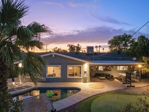 A house with a swimming pool, a covered patio, and a satellite dish.