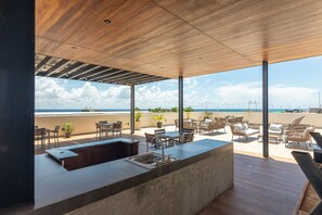 Relax on the ocean-view terrace with a central bar, seating, and scenic views.