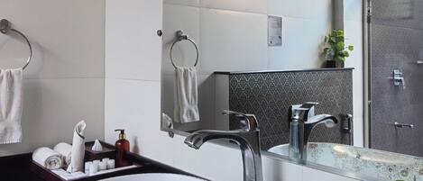 A modern bathroom with a large white sink, black countertop, and a mirror above.