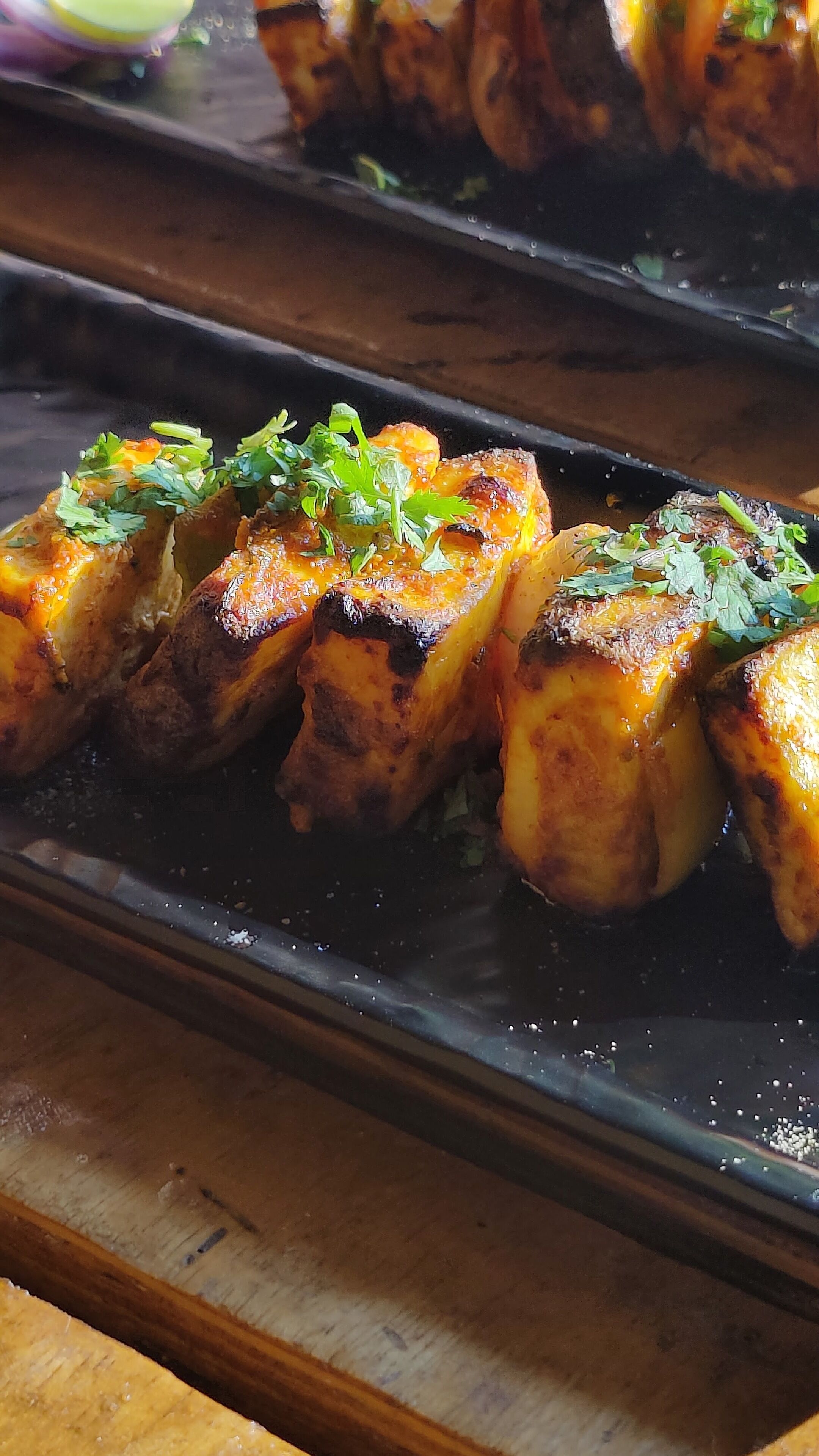 A tray of roasted potatoes garnished with herbs.