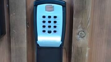 A keypad lock on a wooden surface.