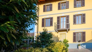 A yellow building with multiple windows and a balcony.