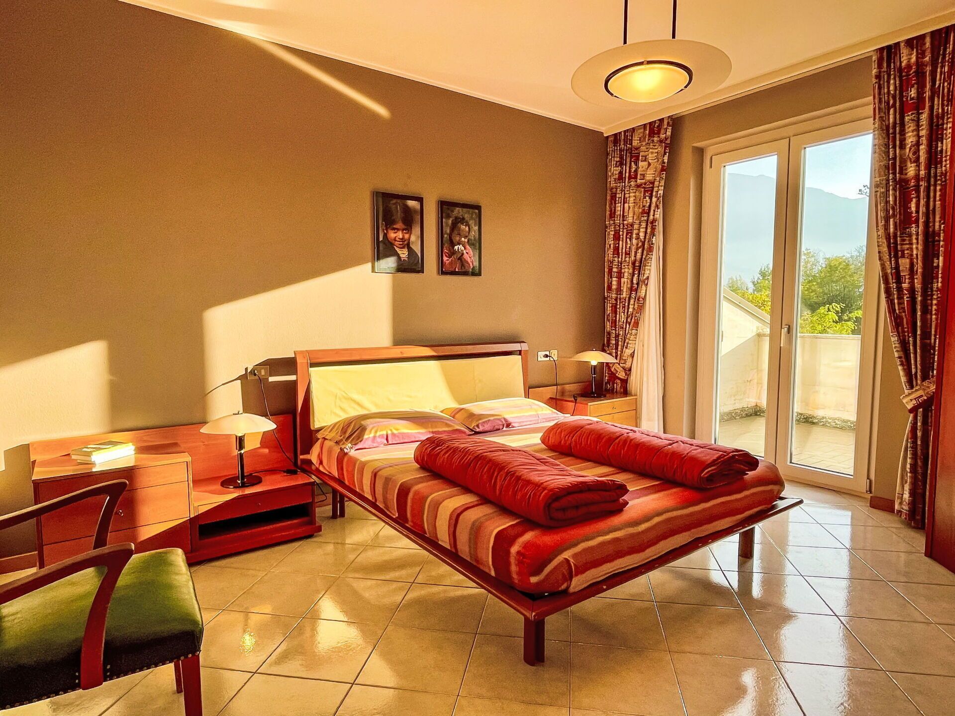 Une chambre à coucher avec un lit, un bureau, une chaise et une fenêtre avec des rideaux.