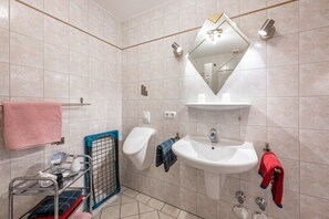 A bathroom with a sink, mirror, towel rack, and a shower area. - Apartment 'Wohnung Gold' with balkon, Shared Garden and Wi-Fi (Süderdeich)
