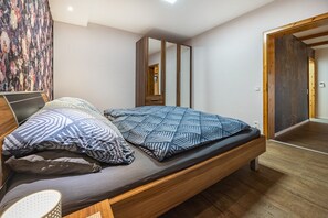 Una camera da letto moderna con un letto in legno, un grande specchio e un'armadio.