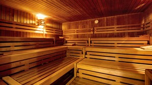 A sauna with wooden benches and a sloped ceiling.