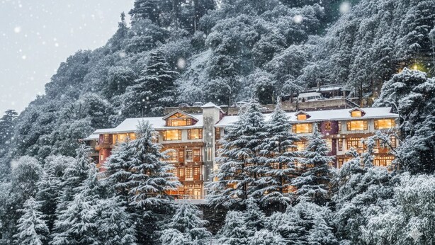 A multi-story building with traditional architecture, surrounded by snow-covered trees. - Pax Hotel Sunrise View Dalhousie (Dalhousie)