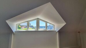Una habitación con tragaluz que ofrece vistas a un paisaje urbano.