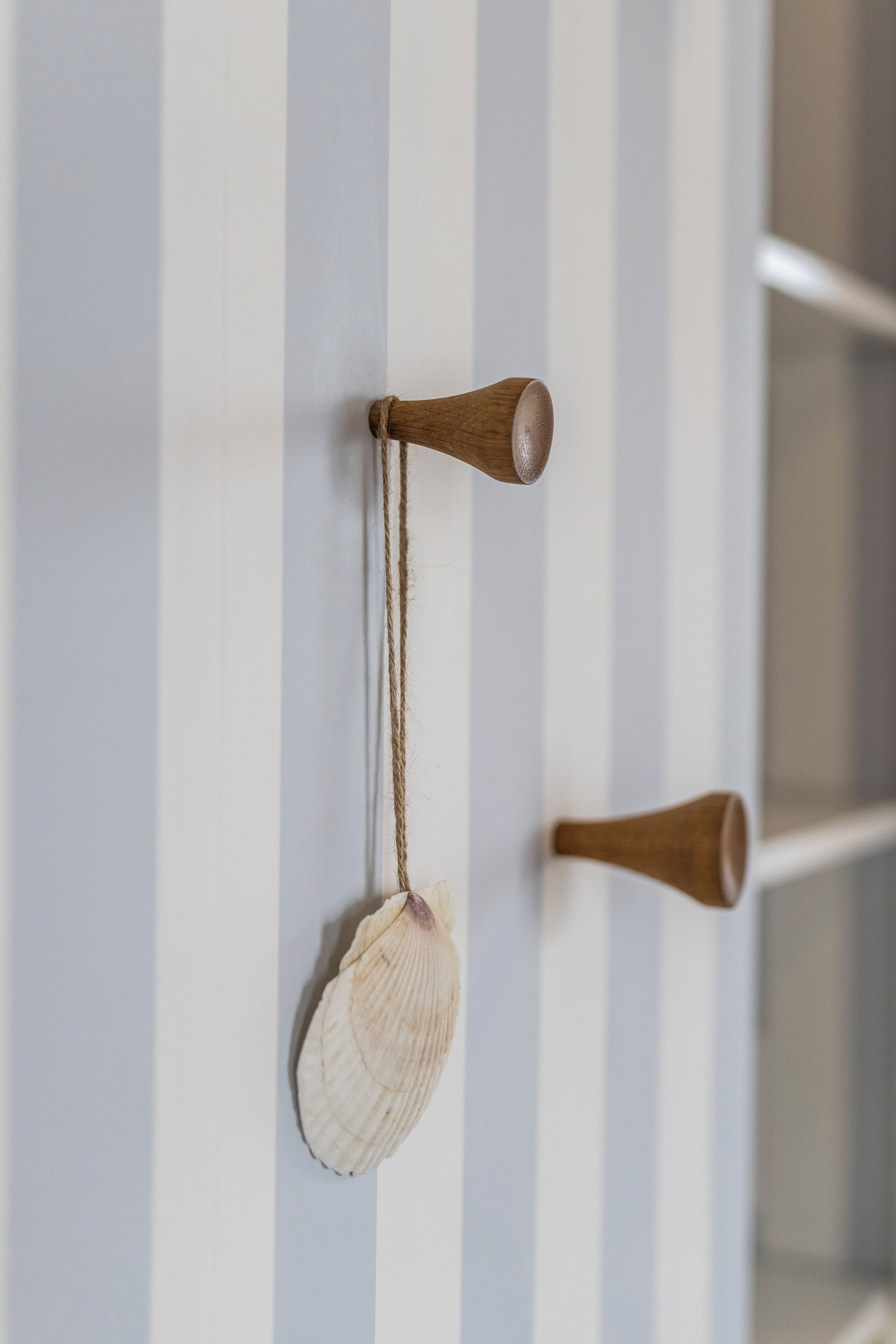 A wall with vertical stripes and two wooden door handles.