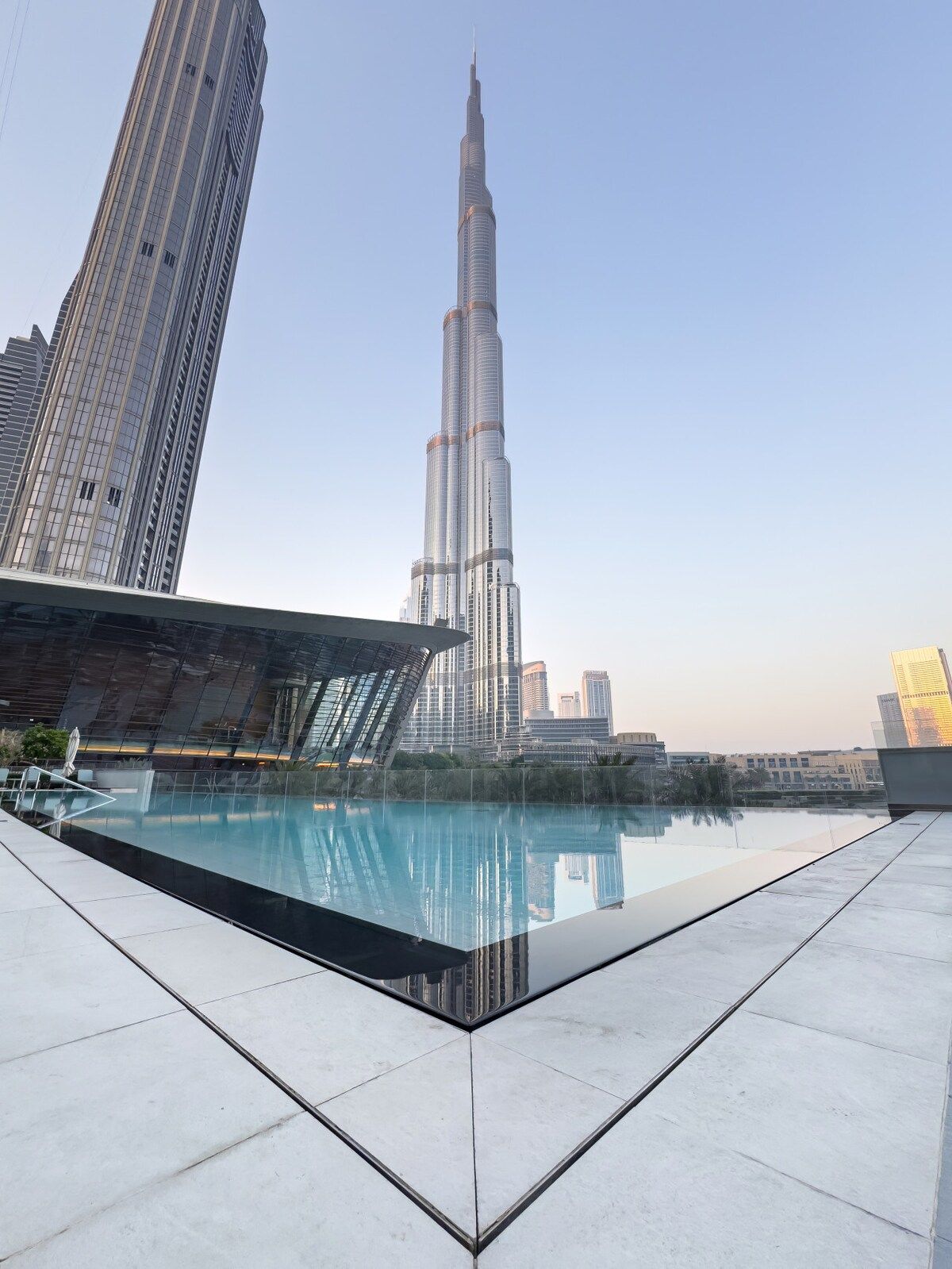 Ein Pool auf dem Dach mit freiem Blick auf den Burj Khalifa und umliegende moderne Gebäude.