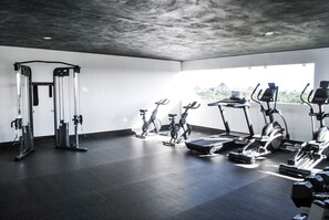 A modern gym with various exercise equipment, including treadmills, stationary bikes, and weight machines.