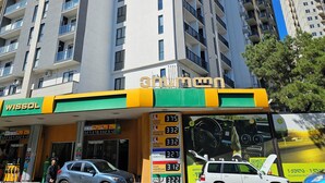Un edificio de varios pisos con una gasolinera en la planta baja.