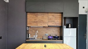 Una cocina moderna con una isla central, dos taburetes de bar, un refrigerador y una estufa.