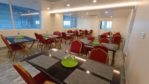 Un salón de conferencias con varias mesas y sillas, equipado con tarjetas de identificación y botellas de agua.