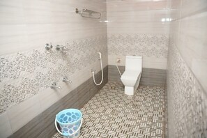 A bathroom with a shower, toilet, and a patterned floor. - Misty Night Jungle Side Resort (Sulthan Bathery)