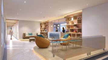 A modern hotel lobby with a central seating area, a reception desk, and a bookshelf filled with books.