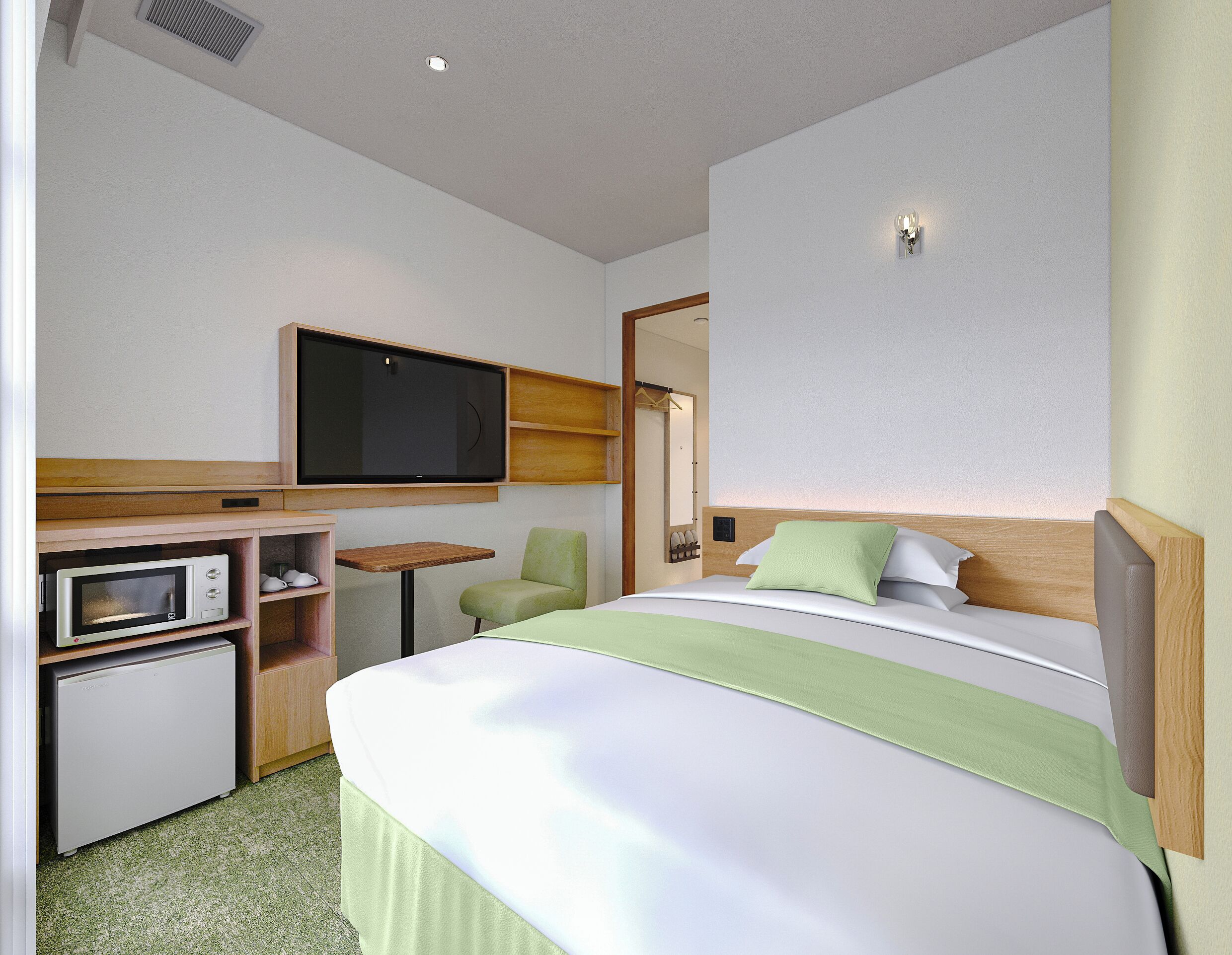 Une chambre d’hôtel équipée d’un lit, d’un téléviseur fixé au mur, d’un four à micro-ondes et d’une petite table.