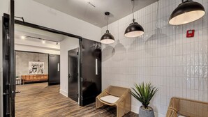 Un hall d'entrée moderne avec un plancher en bois, des meubles en osier et des luminaires suspendus.