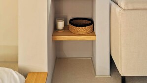 Een hoek van een kamer met een vastgezet houten wandrek, een kleine lamp en een uitzicht op de stad door een raam.