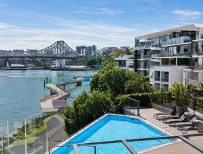 Ein Pool mit Blick auf eine Brücke und eine Stadtlandschaft.
