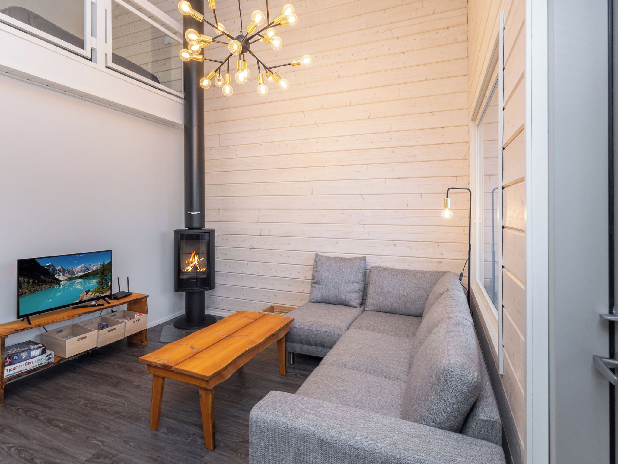 Un salon moderne avec une cheminée, un canapé, une table en bois et un téléviseur.