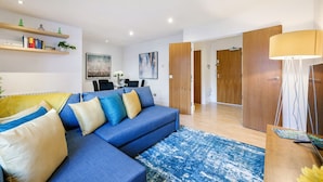 Uma sala de estar moderna com um sofá azul, portas de madeira e um tapete azul.