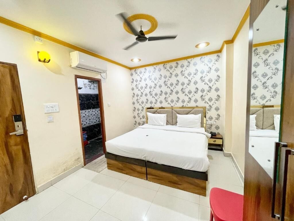 Un dormitorio con cama, ventilador de techo, espejo y puerta.