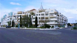 Ein mehrstöckiges Hotel mit einer zentralen Atriumlichtkuppel, Balkonen und einem markanten Turm.