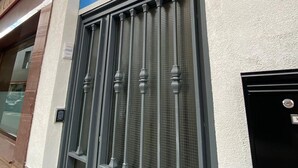 Egy épület homlokzata, amelyen egy nagy ablak található, melyet fémráccsal láttak el, és a felette lévő táblán a „HR El Olivo” felirat olvasható.