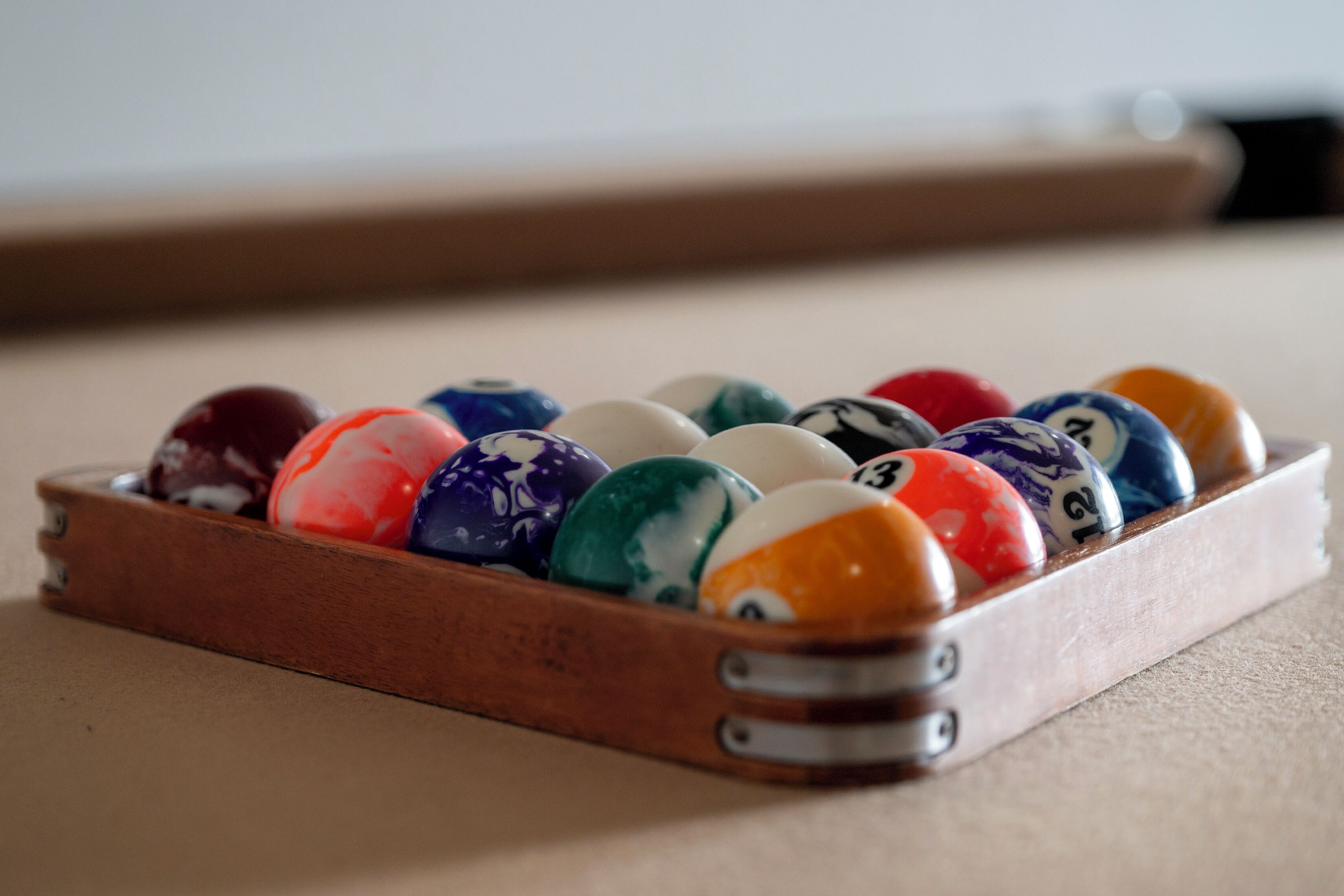 Una mesa de billar de madera con un juego de bolas numeradas.