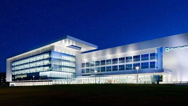 A modern hospital building with a glass facade, a prominent Hillcrest Hospital sign, and a well-lit entrance. - Fenced backyard - Pets OK - 3 Bd 3 Ba (Mayfield Heights)