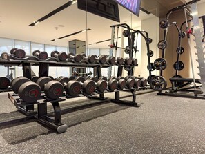 A gym with weightlifting equipment, including dumbbells and barbells.