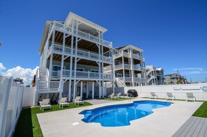 A multi-story building with a pool and outdoor seating. - Stunning 10-bedroom oceanfront home in North Topsail Beach, perfect for large groups. (North Topsail Beach)