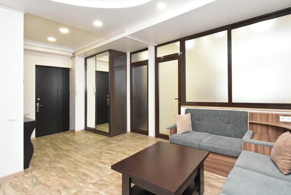 Un interior moderno con un sofá, una mesa de centro y un amplio ventanal.