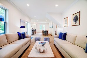 Relax in this stylish living room with two sofas, a coffee table, and a dining area.