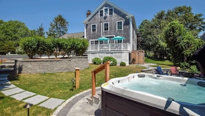 Une maison avec un jacuzzi, une terrasse et un mur en pierre.