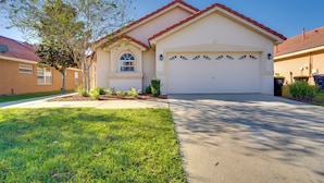 A single-story house with a red roof, a white garage door, and a well-maintained lawn. - 11 Mi to Disney: Pet-friendly Aviana Resort Home! (Davenport)