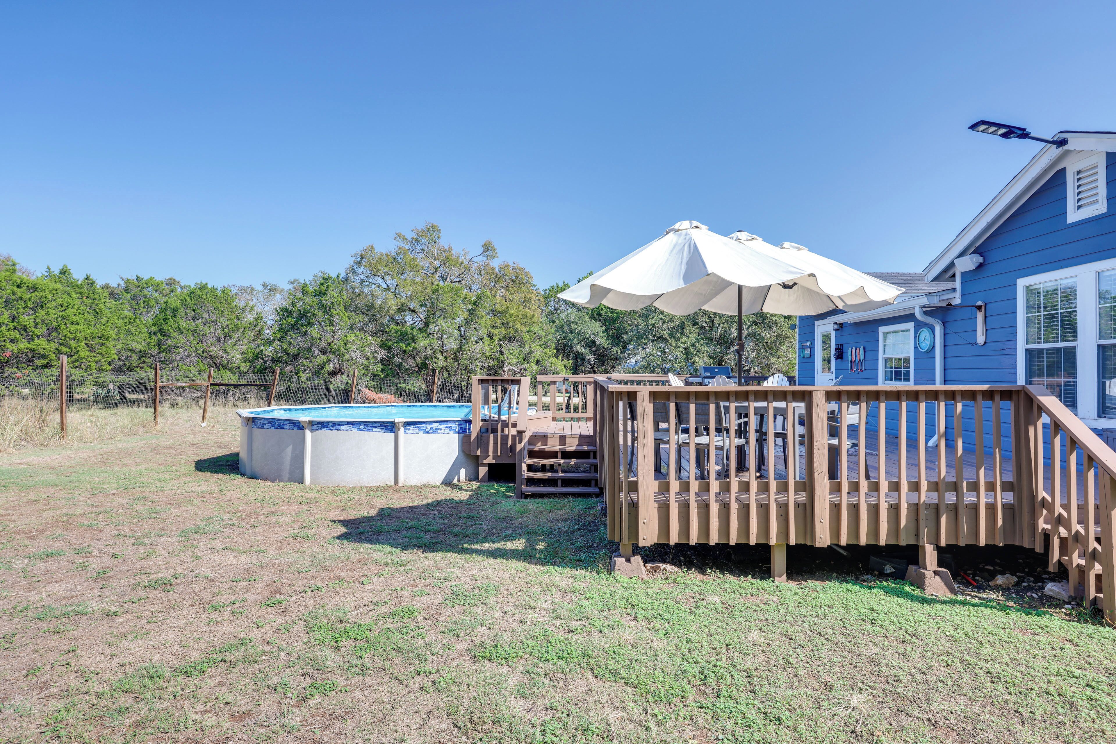 Ein Garten mit Whirlpool, einer Holzterrasse und einem Haus.