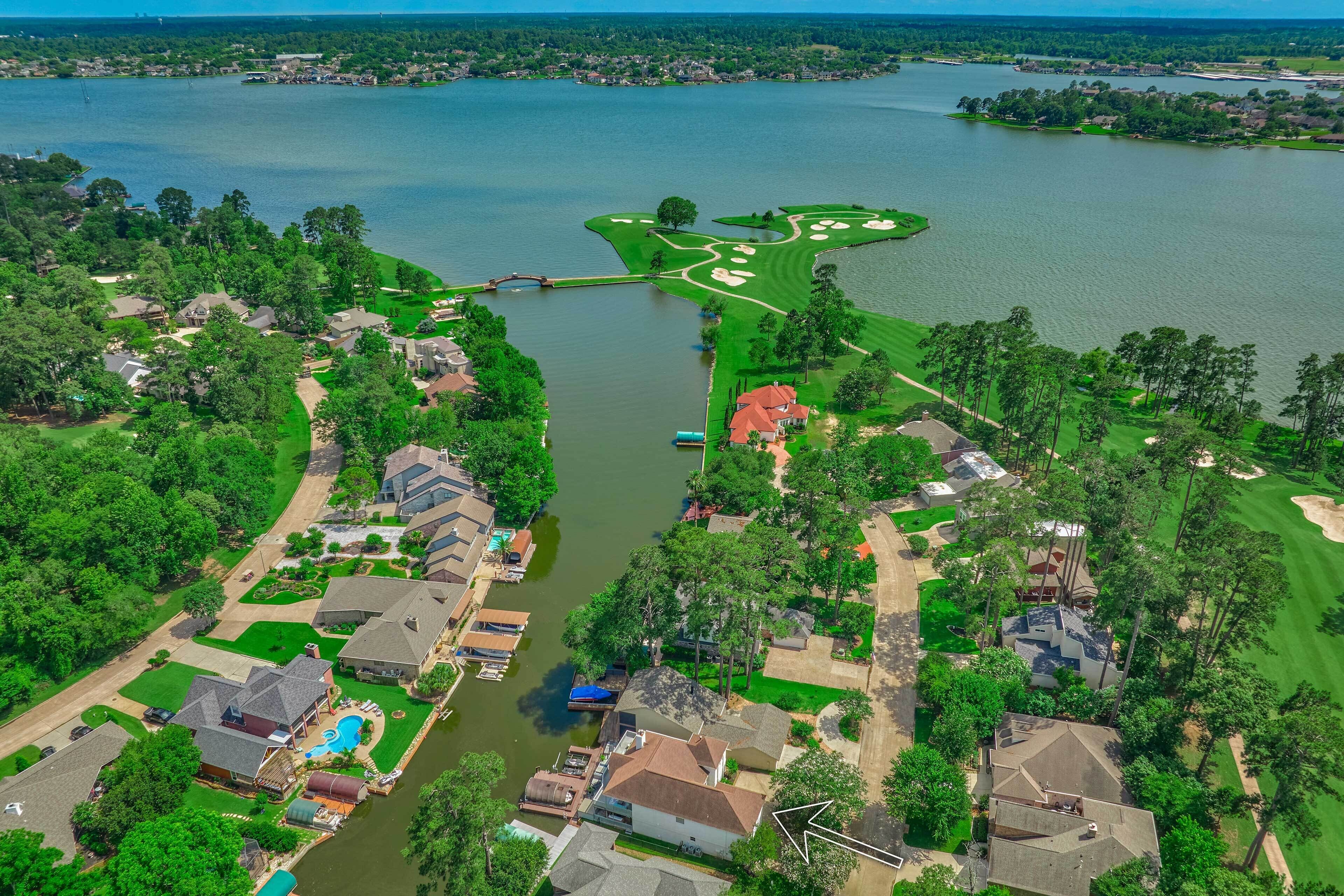 Vista aérea de una zona residencial con casas, un campo de golf y un lago.