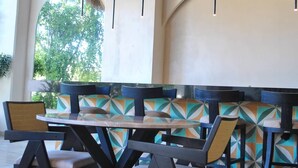 A restaurant with a thatched roof, modern chairs, and a patterned wall. - New Chic Tulum with Rooftop Pool (Tulum)