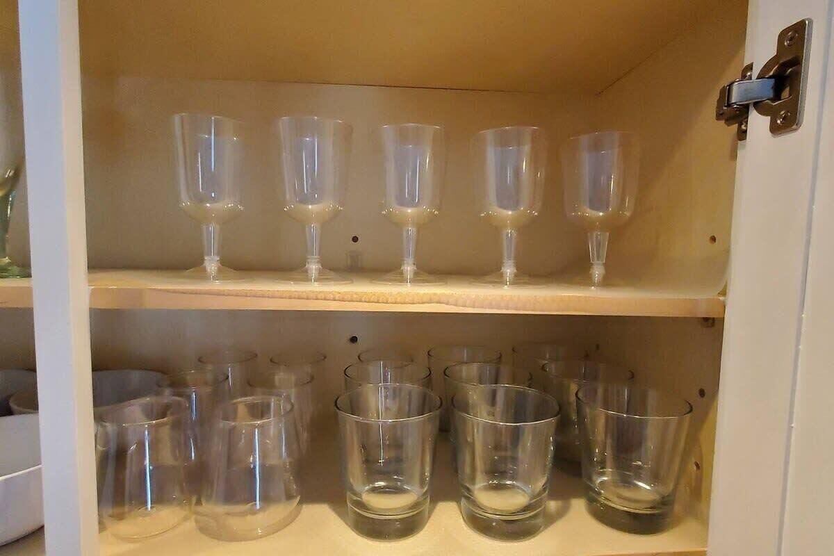 A storage cabinet with multiple shelves holding clear glassware.