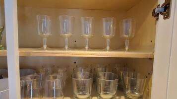 A storage cabinet with multiple shelves holding clear glassware.