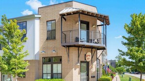 A two-story building with a balcony on the second floor, a sign reading "Riverview Inn," and an American flag. - Rackensack Inn Summar (Bentonville)
