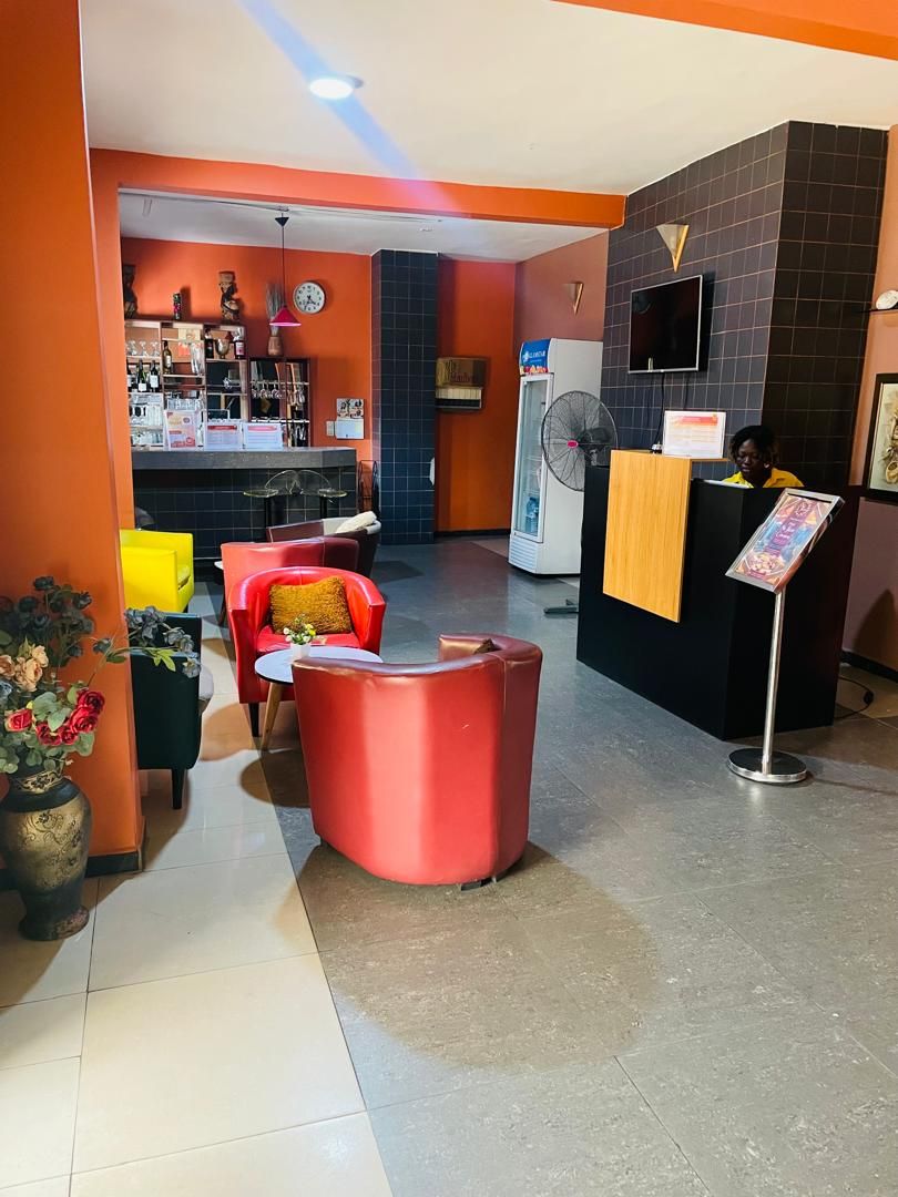 A reception area with a counter, a fan, and seating.