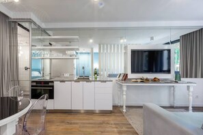 A modern kitchen with a central island, built-in appliances, and a large flat-screen TV.
