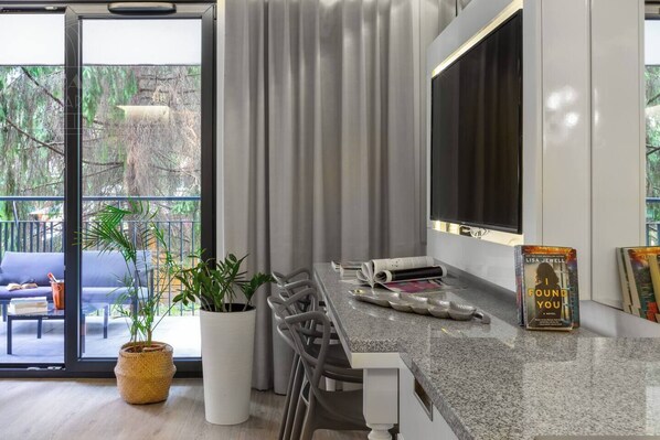 A modern kitchen with a dining area, a large window with curtains, and a book titled 'I Found You' on the counter.