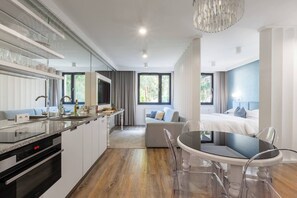 Una cocina moderna con comedor, un sofá y una cama al fondo.