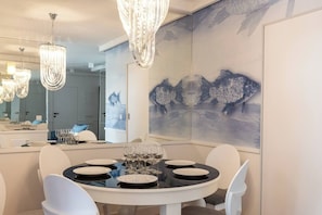 Un comedor con una mesa redonda para seis personas, un espejo grande y un cuadro de un pez en la pared.