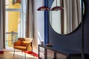 A modern room with a large window, a round mirror, a sofa, and a console table. - The Geometric 3-bedroom apartment (Kraków – Old Town)