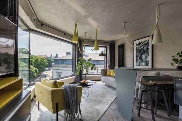 Un apartamento moderno con un ventanal grande, un sofá, un comedor y una cocina.